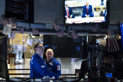 Operadores de la Bolsa de Valores de Nueva York observan a Trump en televisión.
