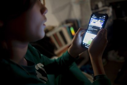 Un joven interacciona a través de un teléfono móvil.