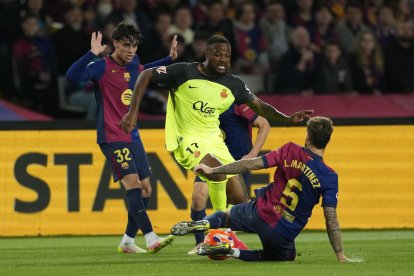 El delantero del Mallorca Cyle Larin (c) juega un balón entre Héctor Fort (i) e Íñigo Martínez, ambos del Barcelona, durante el partido de la jornada 33 de LaLiga que FC Barcelona y RCD Mallorca disputaron en el Estadi Olímpic Lluís Companys. EFE/Alejandro García