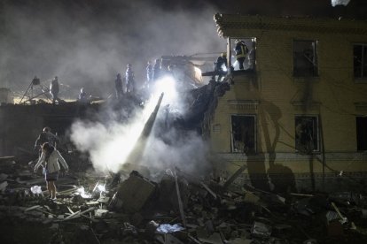 Rescatistas ucranianos trabajan en el lugar donde un cohete impactó esta noche contra un edificio residencial en Kiev. EFE/EPA/SERGEY SHESTAK