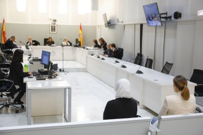 Las dos españolas casadas con yihadistas y repatriadas desde Siria en enero de 2023, Yolanda Martinez Cobos (d) y Luna Fernández Grande (i) este lunes durante el juicio en su contra en la Audiencia Nacional en Marid donde previsiblemente aceptarán una condena de tres años de cárcel a cambio de reconocer su integración en organización terrorista al desplazarse "voluntariamente" con sus maridos a la zona del Dáesh y acogerse a sus postulados. EFE/ Mariscal / POOL