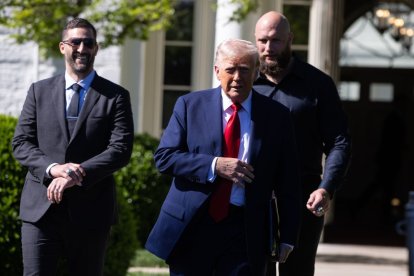 Trump franqueado por el coach de las Águilas de Filadelfia, Nick Sirianni y Lane Johnson.