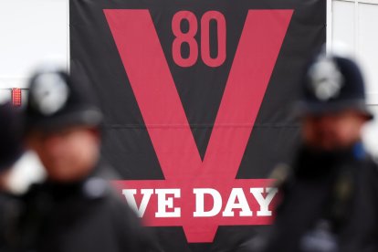 Policías británicos ante un cartel del Día de la Victoria antes del desfile militar para conmemorar el 80 aniversario del fin de la II Guerra Mundial, en Londres, el 5 de mayo de 2025. EFE/EPA/ANDY RAIN