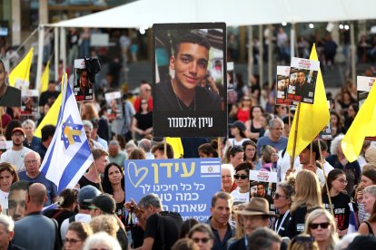 Varias personas se reúnen para ver en directo en una pantalla gigante la liberación del soldado estadounidense de origen israelí Edan Alexander, en la plaza de los rehenes, frente a la base militar de Kirya, en Tel Aviv (Israel).
