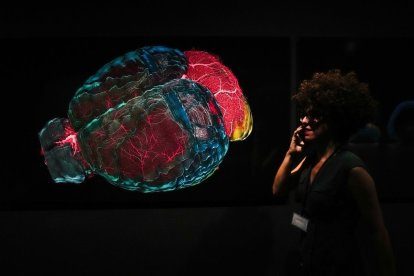 Una mujer pasa por un dibujo del cerebro.
