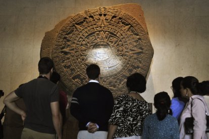 Visitantes del Museo Nacional de Antropología de México contemplan la piedra del Sol.