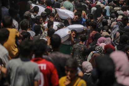 Refugiados palestinos recogen alimentos en Gaza.