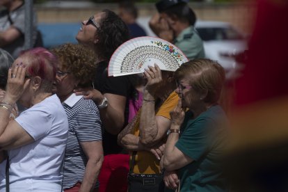 Una mujer se resguarda del sol con un abanico.