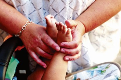 Elisabeth Marcos sujetando los pies del menor en acogida.