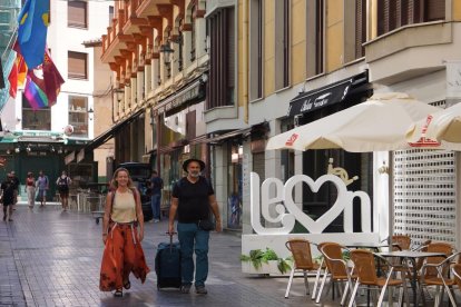 Imagen de dos turistas en la calle Ancha de León.