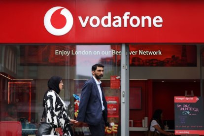 Una pareja ante una tienda de Vodafone.