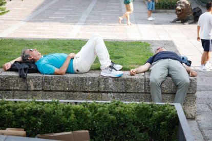 Dos personas descansan a la sombra en la plaza de San Marcelo, ayer en León.