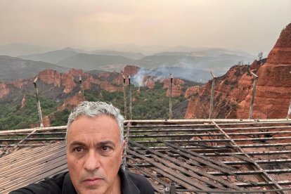 El arquitecto Manuel Neira valorando los daños del mirador de Orellán, con el humo al fondo.