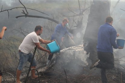 vecinos apagando el fuego en la zona de Molinaseca esta tarde de domingo 24 de agosto. La pesadilla se reactiva.