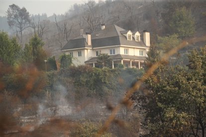 Un chalé salvado del fuego hace unos días, con el monte que le rodeaba calcinado.