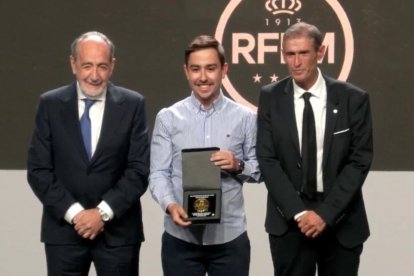 Dani Fidalgo, en el centro, con el galardón entregado por la Federación Madrileña de Fútbol.