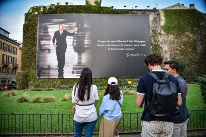 Personas posan ante el mural conmemorativo de Armani tras su muerte.