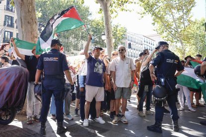 Varias personas con banderas palestinas protestan en el Paseo de la Castellana, este domingo, durante la última etapa de la Vuelta a España que se disputa entre las localidades madrileñas de Alalpardo y Madrid, con un recorrido 103,6 Km.- EFE/ Rodrigo Jiménez.