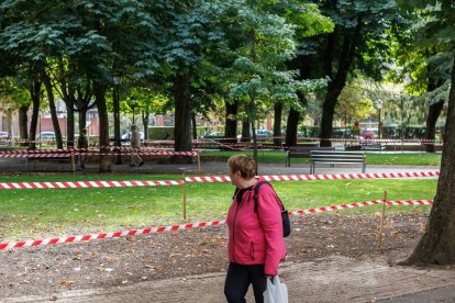 Una señora observa el cierre de parte de las zonas verdes por resiembra.