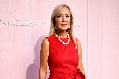Carmen Lomana, con un vestido rojo de tafetán con lazada, en el histórico desfile de Carolina Herrera celebrado en la Plaza Mayor de Madrid.