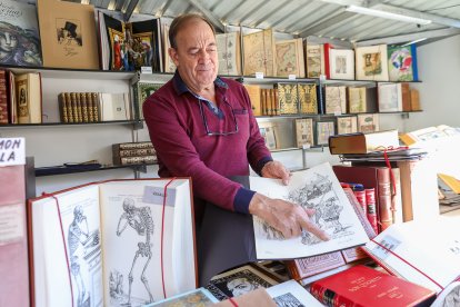 José Antonio Valladares muestra uno de los libros que pone a la venta en la Feria del Libro Antiguo.