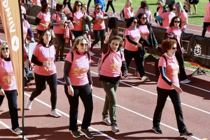 Una mujer hace el signo de la victoria al finalizar la exitosa Carrera de la Mujer en León.