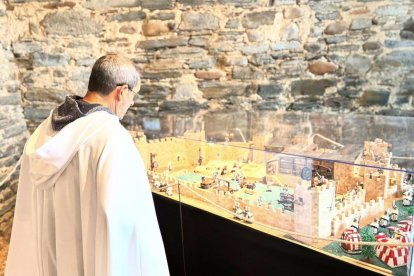 Un templario contempla la maqueta de un castillo.