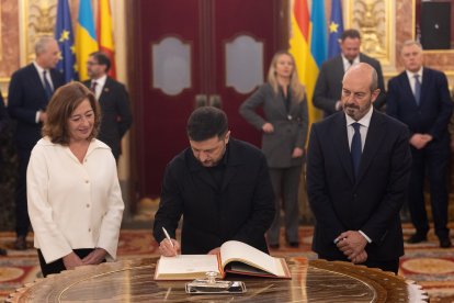 El presidente de Ucrania, Volodimir Zelenski (c), firma el libro de Honor del Congreso, junto a la presidenta del Congreso, Francina Armengol, y con el presidente del Senado, Pedro Rollán (d), en el Congreso.