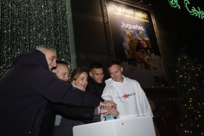 Alvarado y los jugadores accionan el botón de encendido de las luces en El Corte Inglés.