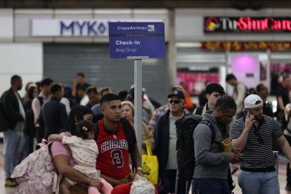 Personas esperan para abordar un vuelo.