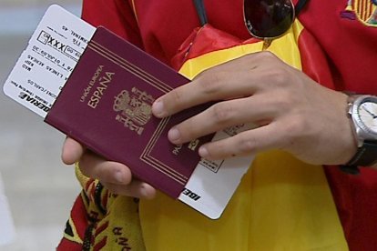 Imagen de archivo de un aficionado español de fútbol con su pasaporte y su tarjeta de embarque en el aeropuerto de Madrid-Barajas. EFE-TV.