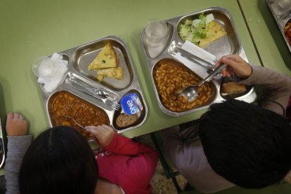 Dos niños, con el menú de un comedor escolar.