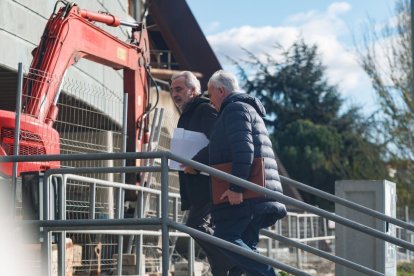 Manuel Carnero entra con la documentación a la Junta de Accionistas acompañado.