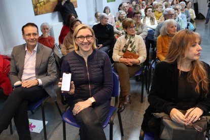 La vicepresidenta y consejera de Familia muestra la aplicación en el móvil.