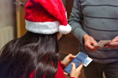En Navidad, cada vez más personas reparten sus décimos por WhatsApp y pagan su parte con Bizum, una tendencia tan cómoda como arriesgada si no se hace bien