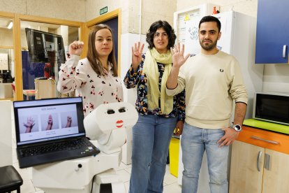 Virginia Riego junto a dos compañeros del Grupo de Robótica de la Universidad de León realizan la señal de socorro.