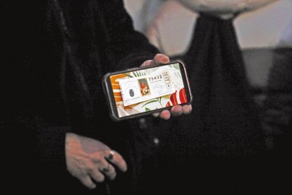 Una mujer enseña una foto de su participación premiada en Villamanín.