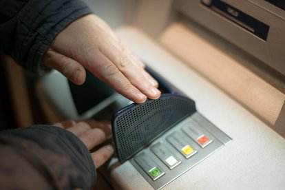 Una persona saca dinero de un cajero.