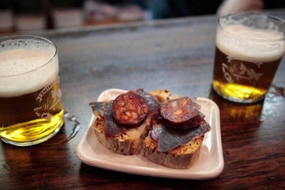 Tapa clásica de cecina y chorizo dulce que acompaña la caña en el Bar Entrepeñas, una experiencia de sabor leonés en pleno Barrio Húmedo.