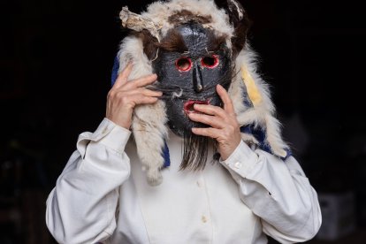 Un participante ajusta su máscara ritual del Antruejo leonés, una tradición de más de 2.000 años que cada invierno transforma los pueblos de la provincia de León.