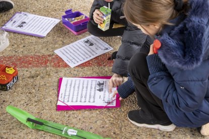 Un grupo de niños repasa música en el patio de su colegio.