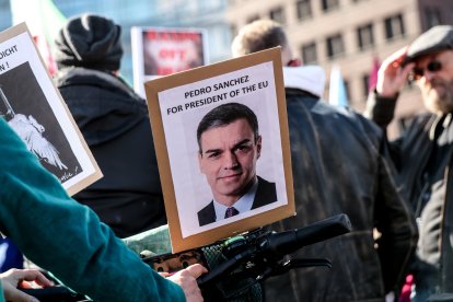 Un manifestante sostiene una pancarta en apoyo del presidente del Gobierno español, Pedro Sánchez, durante una concentración bajo el lema «¡No a la guerra contra Irán! ¡Paz en lugar de inflación provocada por la guerra!», en Berlín, Alemania, el 21 de marzo de 2026.