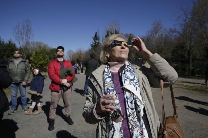 Varias personas observan un eclipse parcial de Sol en León.