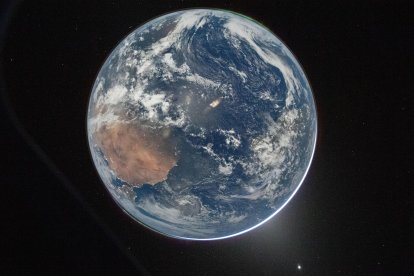 Imagen tomada de la cuenta oficial en X de la @NASA que muestra una fotografía de la Tierra tomada por la tripulación de Artemis II, captada con una velocidad de obturación lenta, mostrando remolinos de nubes blancas, una gran masa terrestre de color marrón que corresponde a África, dos auroras boreales en la parte superior derecha e inferior izquierda, y la luz zodiacal (abajo a la derecha). E.