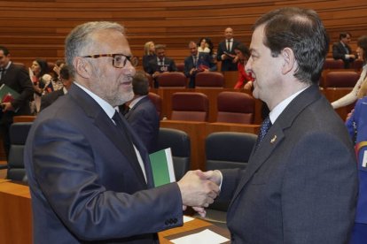 El presidente en funciones de la Junta de Castilla y León, Alfonso Fernández Mañueco (d), saluda al nuevo portavoz de Vox en las Cortes, Carlos Pollán (i), durante la sesión plenaria de este martes