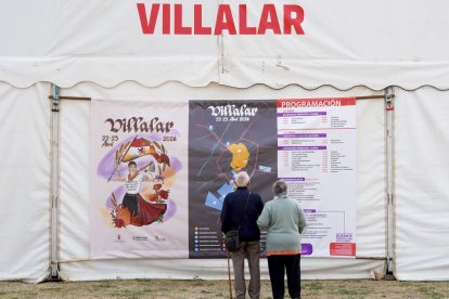 Dos vecinos de Villalar contempla el programa instalado en la carpa para la celebración de hoy.
