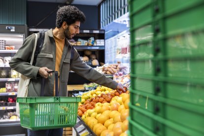 Un joven compra en un supermercado