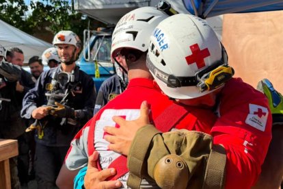 Dos bomberos se abrazan tras el rescate.