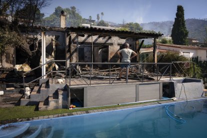 Un hombre contempla los restos de una vivienda calcinada en la localidad de Calonge.