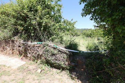 Acceso a la finca de cerezos con el precinto judicial donde apareció el cuerpo golpeado del vecino de Arganza.